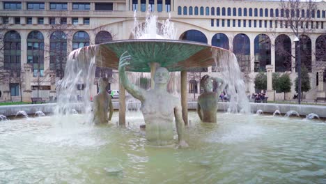 old roman statue in a water fountain, looking like it's taking a selfie, roman architecture in montpellier in south of france