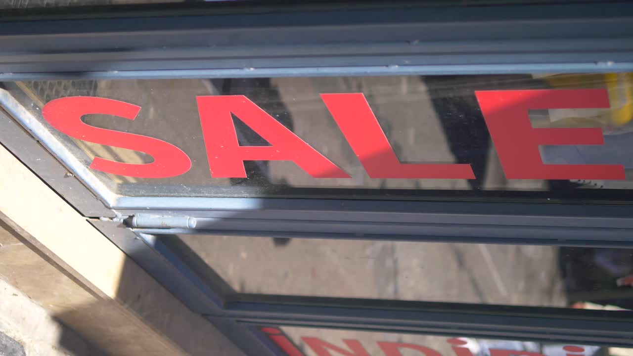Red 'SALE' sign displayed on a shop window