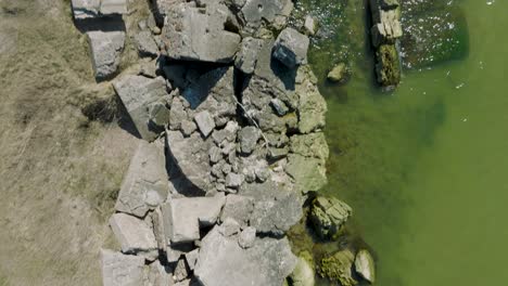 beautiful aerial establishing view of karosta concrete coast fortification ruins, calm baltic sea, sunny summer day, birdseye drone shot moving forward