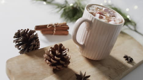 video of mug of christmas chocolate on wooden board and copy space on white background