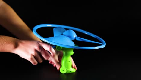 hand launches toy helicopter using pull-string mechanism