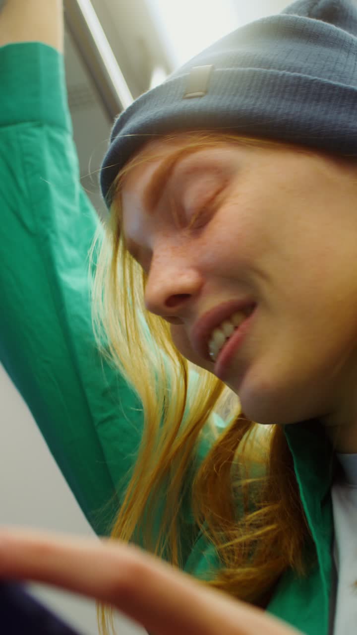 Close-up portrait of a young woman with red hair and freckles wearing a blue beanie