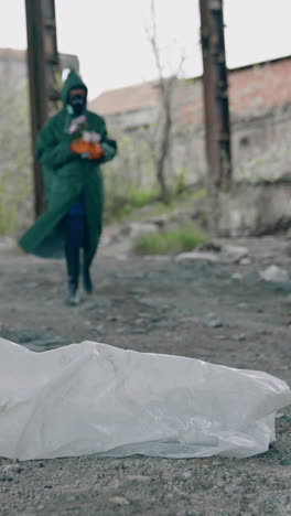 human in protective suit in radioactive place. man in safety costume and gas mask with flowers walking in abandoned place. chemical attack. pollution of the environment. vertical video