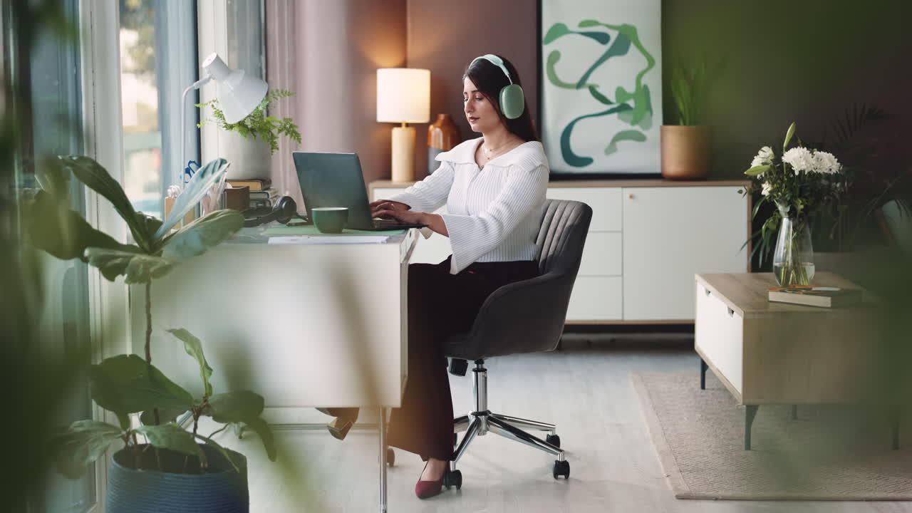 Femme travaillant à domicile avec un ordinateur portable et des écouteurs