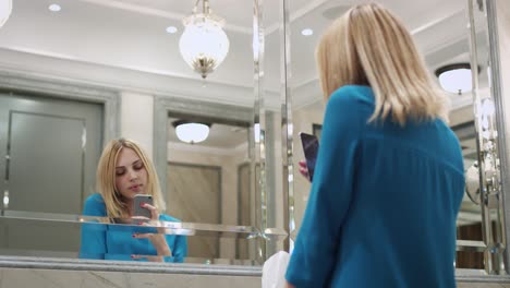 Bella-Mujer-Haciendo-Selfie-Foto-En-El-Espejo-Frontal-Del-Teléfono-Móvil-En-El-Baño.