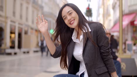 woman sitting on a bench in town waiting