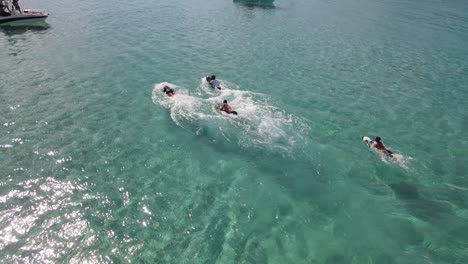 aerial overhead view of holiday makers using electric assisted kick board in balearic sea in ibiza