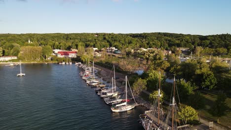 Antikes-Segelschiff-In-Den-Docks-Von-Suttons-Bay,-Michigan,-Luftdrohnen-Aufstiegsansicht