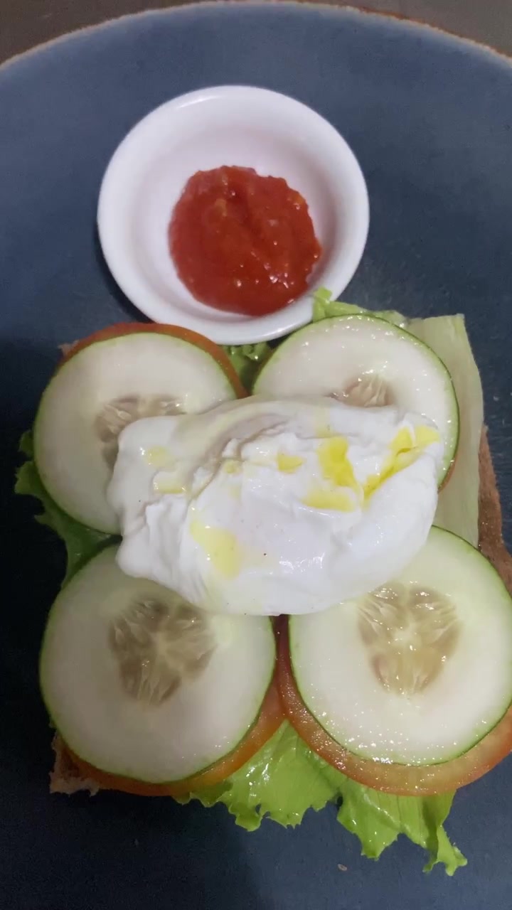 Uovo in camicia su pane tostato con cetriolo e pomodoro