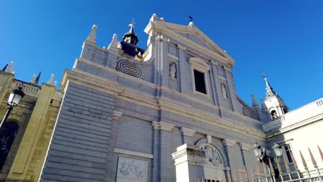 looking upward to catedral de la almudena huge church in city center of madrid catholic monument on blue sky daytime