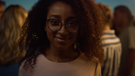 african woman posing camera. eyeglasses girl standing on party background.