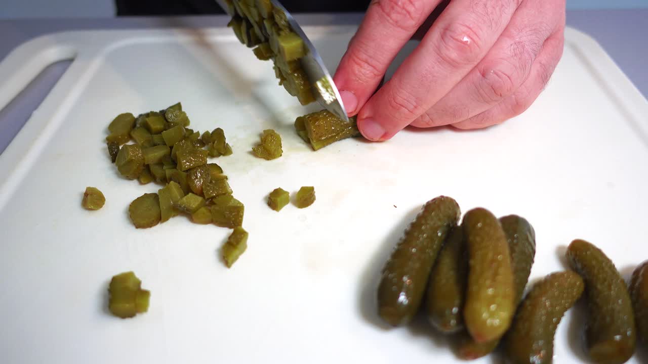 프랑스 샐러드 준비, 남성 손으로 큰 요리사 칼로 피클을 자르는 것, 아무도, 흰색 커팅 플레이트, 요리 개념