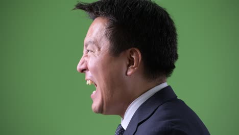 mature japanese businessman against green background
