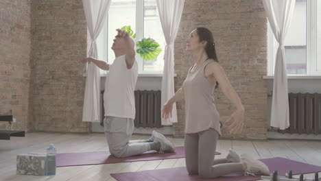 viejos hombres y mujeres haciendo ejercicios en la alfombra de yoga en casa