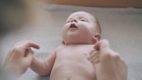 el niño está en la cama y el pediatra le masajea las manos.