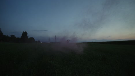 person with smoke bomb in a field at dusk