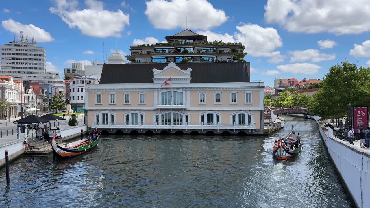 Moliceiro boats on a scenic canal in Aveiro, Portugal, with historic buildings