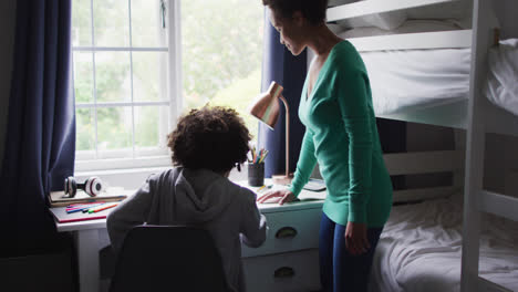 Mixed-race-mother-and-daughter-drawing-in-a-notebook