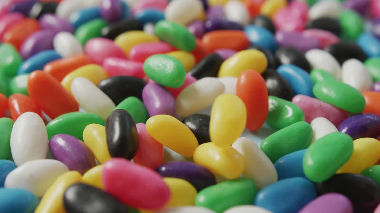 video de primer plano de dulces multicolores que caen sobre un fondo azul