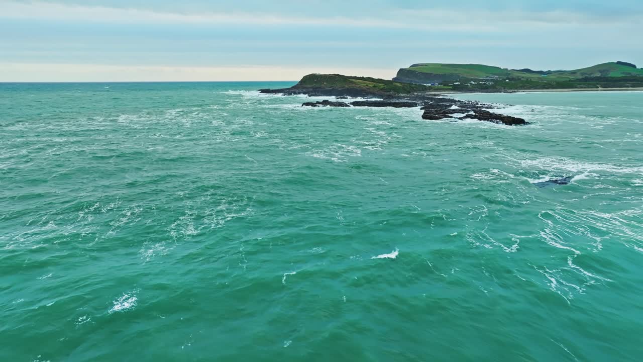 포포이즈 만 (porpoise bay) 의 가장자리에 있는 바위 바다의 공중 전망 (aerial overview of rocky ocean waters at the edge of porpoise bay, new zealand)