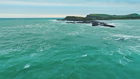 Aerial-overview-of-rocky-ocean-waters-at-edge-of-Porpoise-bay-New-Zealand