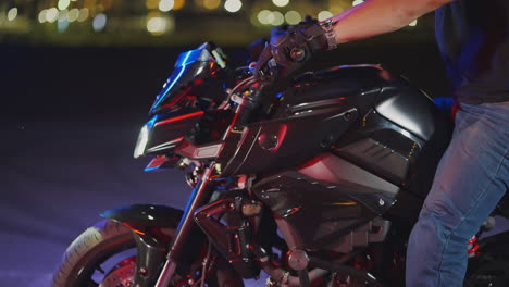 man riding a motorcycle at night in the city