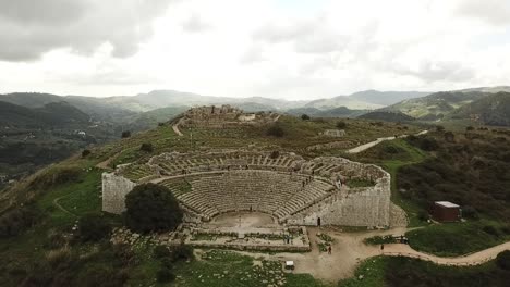 Vista-De-Drones-Del-Teatro-En-Segesta,-Sicilia,-Italia,-Tiro-Hacia-Atrás