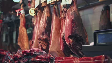 selection of cured hams and meats at a market