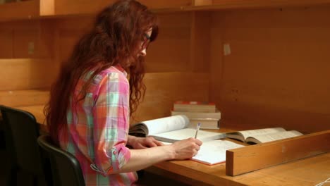 estudiante leyendo un libro de la biblioteca