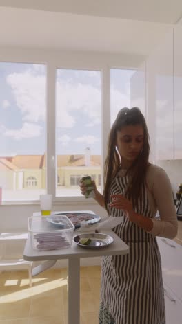 woman preparing fish in kitchen