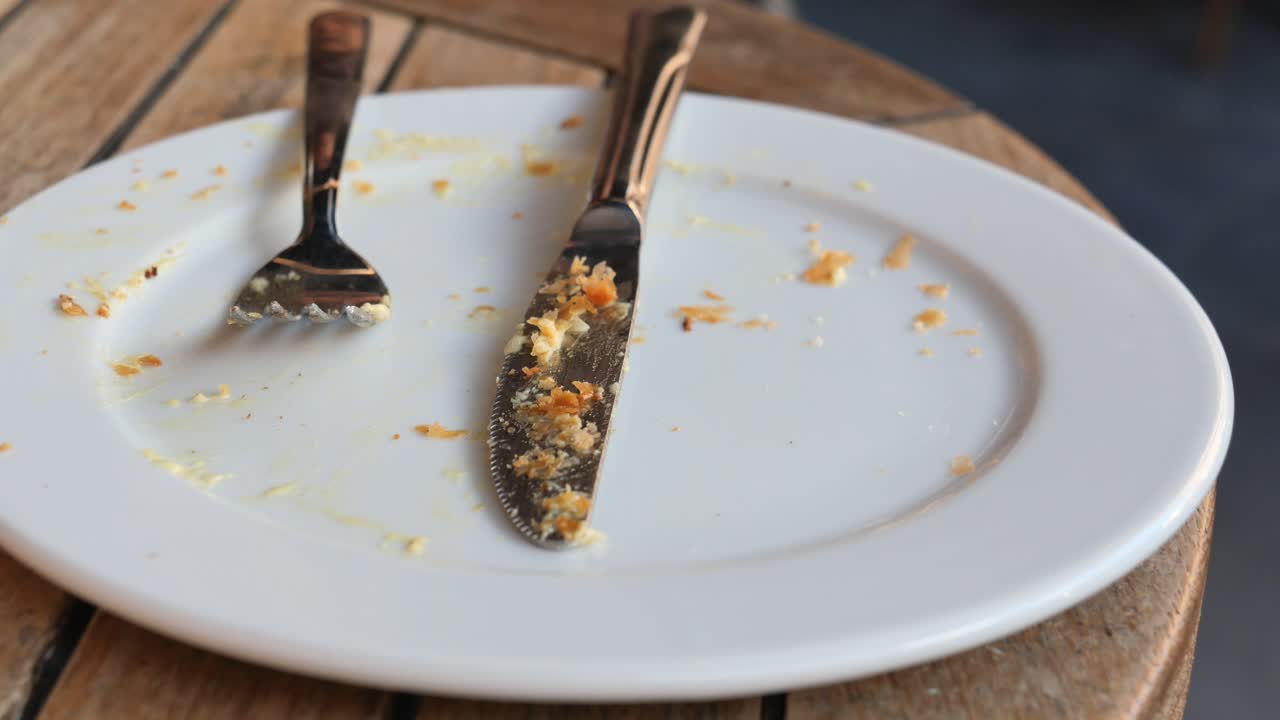 Empty Plate with Utensils and Crumbs