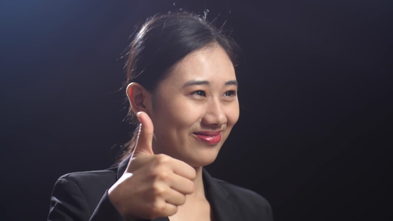 미소 짓는 사업가 여자가 엄지 손가락을 들고