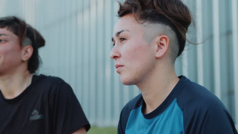 cheerful female friends chatting after soccer training outdoors