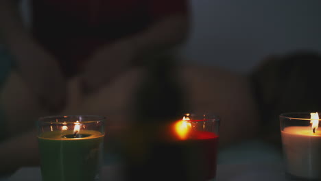el terapeuta hace masajes al cliente enfermo en el salón oscuro.