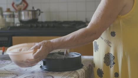 Eine-ältere-Frau-Gibt-Den-Teig-In-Die-Pfanne,-Um-Einen-Schokoladenkuchen-Zu-Backen