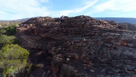 escalador masculino caminando sobre una montaña rocosa 4k