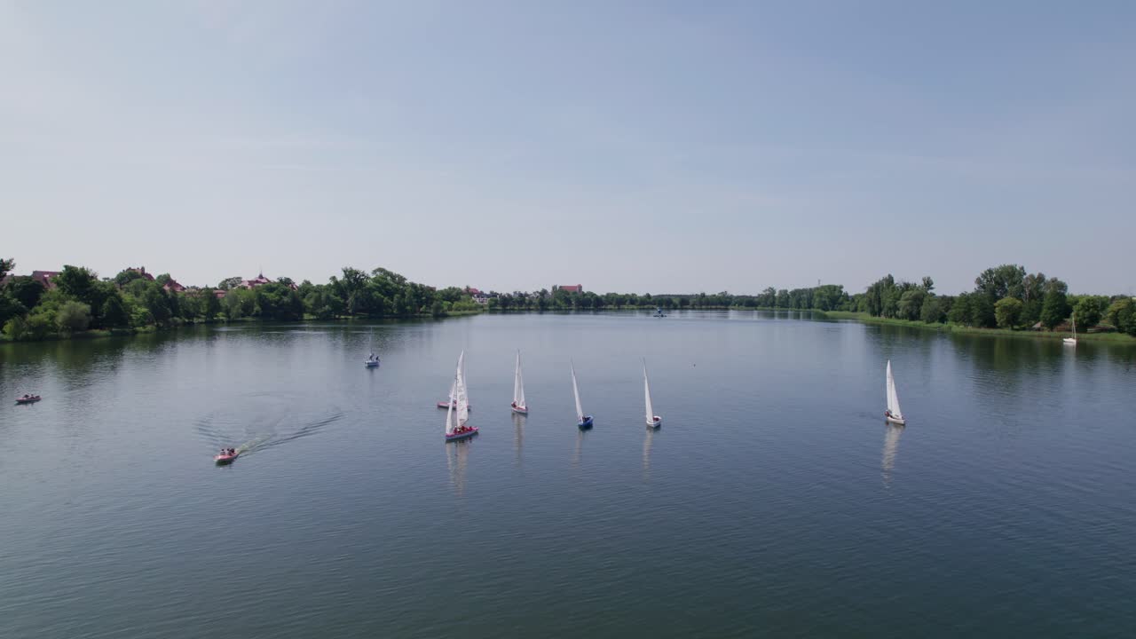 6 veleros en un lago, tiempo soleado, zoom out drone shot