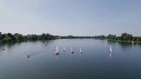 6-sailboats-on-a-lake,-sunny-weather,-zoom-out-drone-shot