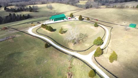 aerial pullback of a fence pin and green barn in frankfort kentucky on a beautiful green horse farm