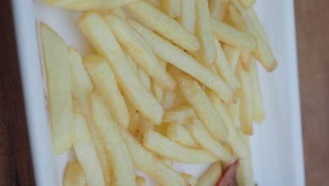 close-up of a plate with meat and vegetable stir-fry, french fries, and sauce