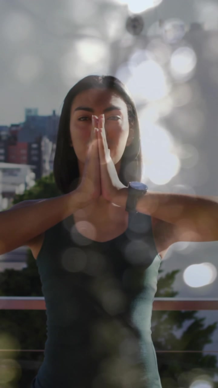 Animación de luces brillantes sobre una mujer practicando yoga