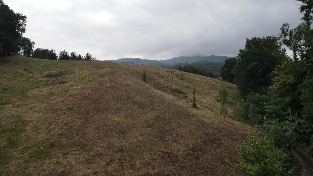 Aerial video of a forest in the Basque Country with vegetation and some houses