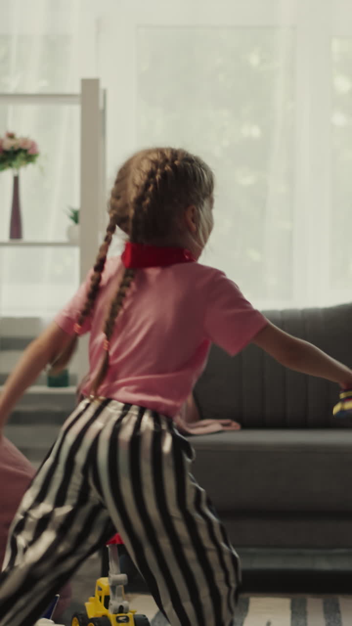 Couple of kids siblings has fun playing with toy swords in light room. Cheerful toddler boy wearing pirate costume defends from playful attack of sister