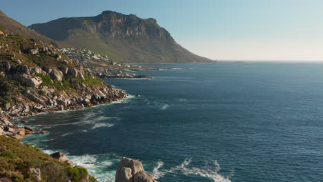 rocky coastline of llandudno hit by ocean waves in cape town, south africa