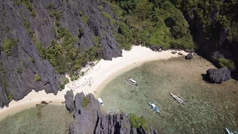 4k aerial drone shot of beach and limestone rocks at secret beach at miniloc island, philippines