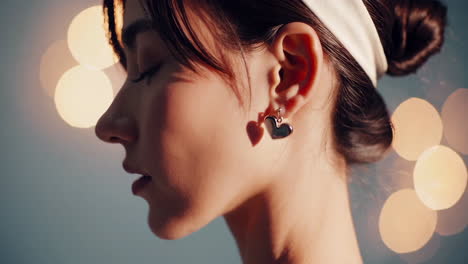 woman with heart earrings and bokeh lights