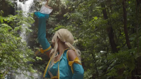 Lucy-Heartfilia-Anime-Cosplayer-Mit-Blick-Auf-Einen-Erstaunlichen-Wasserfall,-Der-über-Die-Klippen-Im-Karibischen-Dschungel-Von-Trinidad-Fließt