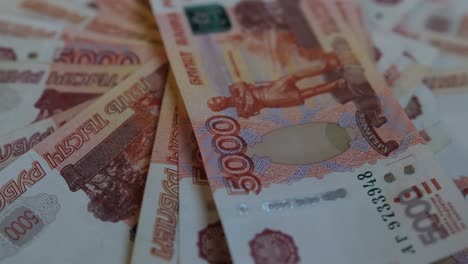 un paquete de papel moneda 5000 billetes rusos se encuentra en una plataforma giratoria en el sentido de las agujas del reloj.