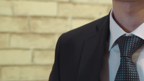 el novio elegante se pone una chaqueta de traje preparándose para la boda