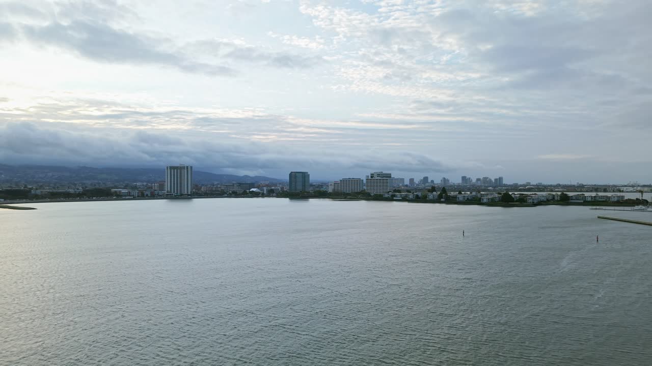 Sweeping over Emeryville's coastline, the drone highlights sparkling water meeting winding walking paths.